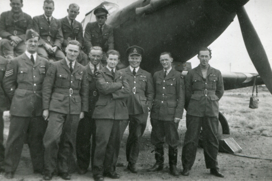 No. 256 Squadron crews pose next to one of their Defiants - Flt. Lt. D.R. West sits on the wing - top row, furthest to the right and Sgt. R.T. Adams directly below him - bottom row third from the left. (Photo: Russell Brown Collection)